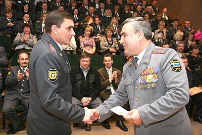  Нагрудный знак «За верность долгу» из рук Е. Меркулова (справа) получает майор, старший участковый уполномоченный милиции И. Аниконов (Фото Юрия Шестернина)