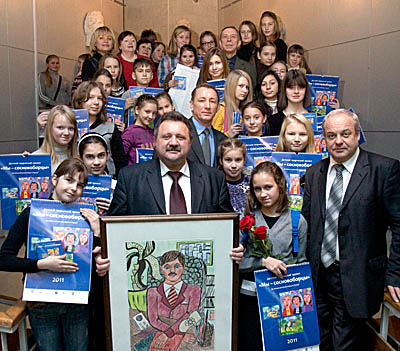  Директор ЛАЭС В. Перегуда (в центре) получил в подарок от юных художников свой портрет. (Фото Юрия Шестернина)