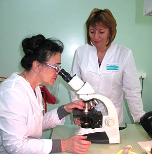  Заведующая микробиологической лабораторией В. Семченко (слева, за микроскопом) и фельдшер-лаборант С. Кудрявцева (Фото Нины Князевой)