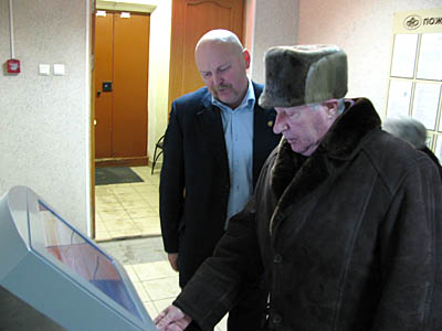  Управляющий Пенсионным фондом по Сосновому Бору А. Сироткин (слева) наблюдает, как справляются посетители с новой системой (Фото Виктора Поповичева)