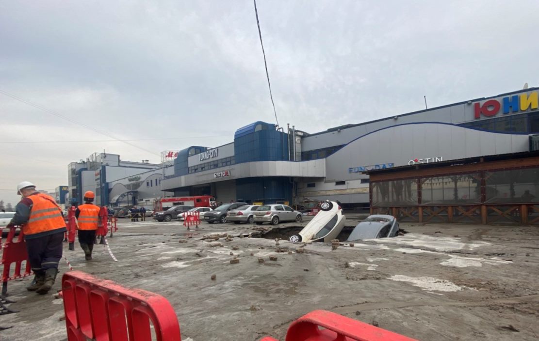 Три машины утонули в огромной яме на парковке в Петербурге из-за прорыва трубы 