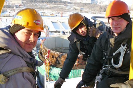 На высоте семидесяти трех метров над строящимся реактором  энергоблока № 1 слева направо: Алексей Дмитриев, Леонид Новожилов, Александр Якимов